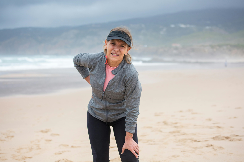 woman on the beach in pain